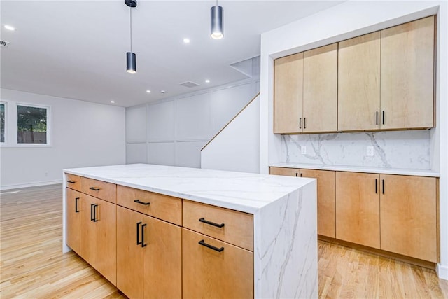 12 Daggett Ct Unit 2, Providence, RI 02906 - kitchen featuring light wood-style floors, light stone countertops, tasteful backsplash, decorative light fixtures, and recessed lighting