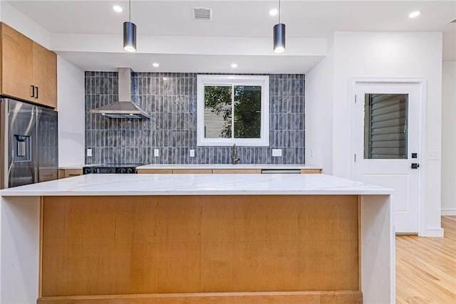 12 Daggett Ct Unit 2, Providence, RI 02906 - kitchen featuring wall chimney exhaust hood, tasteful backsplash, light stone counters, stainless steel fridge, and recessed lighting