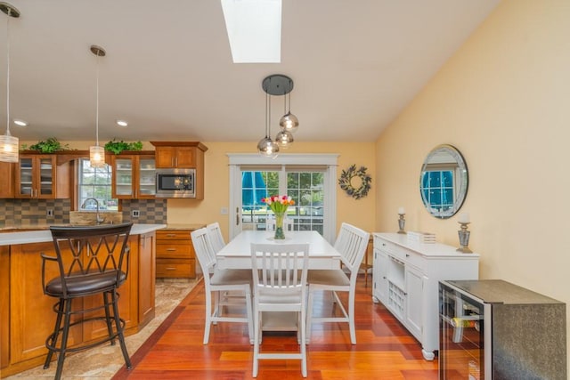 136 Youngs Ave, Coventry, RI 02816 - dining space featuring light wood-style floors, wine cooler, lofted ceiling, and recessed lighting