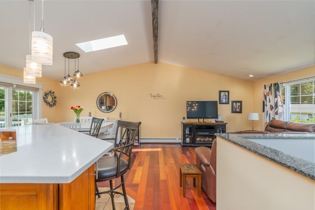 136 Youngs Ave, Coventry, RI 02816 - kitchen featuring a skylight, a baseboard heating unit, open floor plan, brown cabinets, and light wood-type flooring