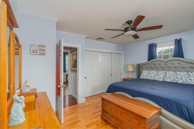 136 Youngs Ave, Coventry, RI 02816 - bedroom with light wood-type flooring, a textured ceiling, a closet, crown molding, and a ceiling fan