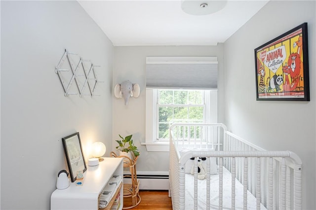 280 S Pierce Rd, East Greenwich, RI 02818 - bedroom with a baseboard heating unit, wood finished floors, and a nursery area