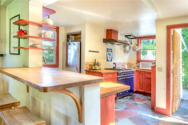 24 Old Beach Rd, Newport, RI 02840 - kitchen featuring stainless steel appliances, butcher block countertops, open shelves, and a peninsula