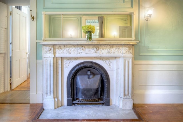 24 Old Beach Rd, Newport, RI 02840 - detailed view of a decorative wall, a wood stove, wood finished floors, and wainscoting