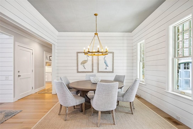7 Spring Pond Rd, Westerly, RI 02891 - dining space featuring a chandelier, plenty of natural light, light wood-type flooring, and wood walls