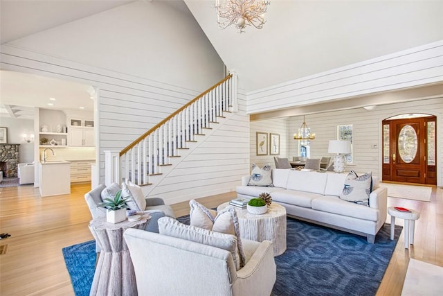 7 Spring Pond Rd, Westerly, RI 02891 - living area with a chandelier, high vaulted ceiling, light wood-style floors, wood walls, and stairway