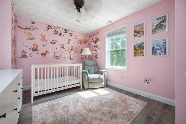 3560 Diamond Hill Rd, Cumberland, RI 02864 - bedroom with a crib, dark wood finished floors, and a ceiling fan