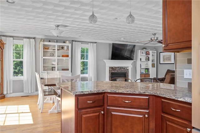 3560 Diamond Hill Rd, Cumberland, RI 02864 - kitchen featuring plenty of natural light, a premium fireplace, light wood finished floors, crown molding, and ceiling fan