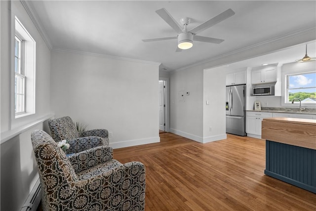 621 Thames St Unit C, Newport, RI 02840 - living area with a baseboard radiator, light wood-style flooring, a ceiling fan, and ornamental molding