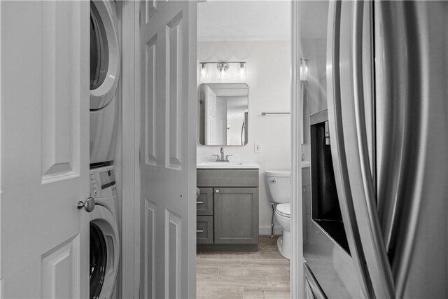 621 Thames St Unit C, Newport, RI 02840 - bathroom with stacked washing machine and dryer, vanity, and wood finished floors
