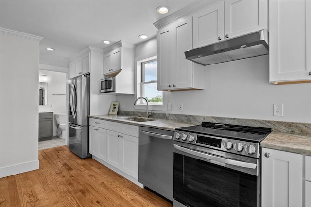 621 Thames St Unit C, Newport, RI 02840 - kitchen with appliances with stainless steel finishes, under cabinet range hood, white cabinetry, light wood-style flooring, and recessed lighting