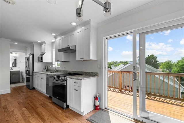 621 Thames St Unit C, Newport, RI 02840 - kitchen with stainless steel appliances, ornamental molding, light wood-type flooring, under cabinet range hood, and white cabinetry