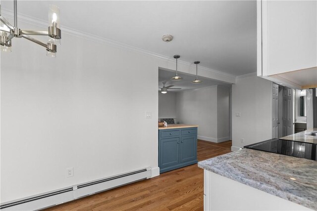 621 Thames St Unit C, Newport, RI 02840 - kitchen with a baseboard radiator, blue cabinets, crown molding, light wood finished floors, and ceiling fan