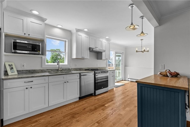 621 Thames St Unit C, Newport, RI 02840 - kitchen with stainless steel appliances, baseboard heating, ornamental molding, under cabinet range hood, and plenty of natural light
