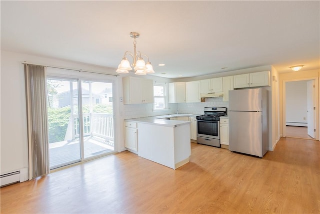 22 Gage St Unit 101, Providence, RI 02909 - kitchen featuring appliances with stainless steel finishes, white cabinets, a chandelier, under cabinet range hood, and decorative backsplash