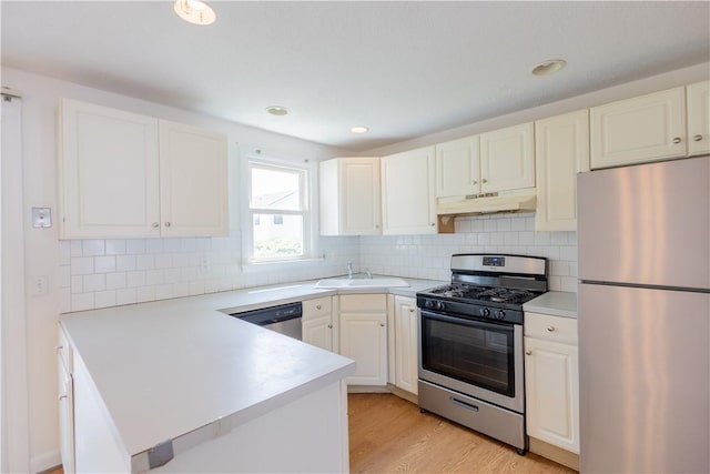 22 Gage St Unit 101, Providence, RI 02909 - kitchen with appliances with stainless steel finishes, under cabinet range hood, light countertops, a peninsula, and recessed lighting