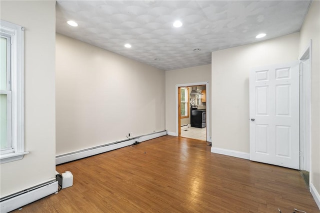 423 Pine St, Central Falls, RI 02863 - empty room with a baseboard heating unit, wood finished floors, and recessed lighting
