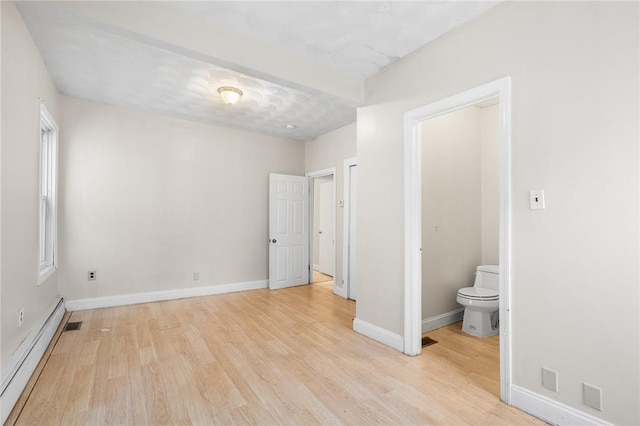 423 Pine St, Central Falls, RI 02863 - unfurnished bedroom with a baseboard heating unit, light wood-style floors, and connected bathroom