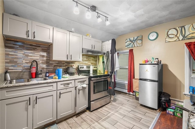 423 Pine St, Central Falls, RI 02863 - kitchen featuring appliances with stainless steel finishes, under cabinet range hood, tasteful backsplash, light wood finished floors, and light countertops