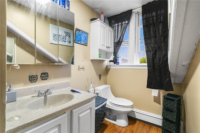 423 Pine St, Central Falls, RI 02863 - bathroom featuring a baseboard heating unit, plenty of natural light, vanity, and wood finished floors