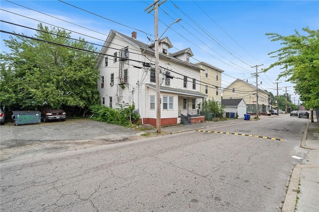 423 Pine St, Central Falls, RI 02863 - view of front facade featuring a chimney and uncovered parking