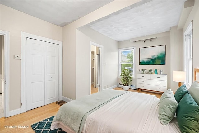 423 Pine St, Central Falls, RI 02863 - bedroom with light wood-style floors and a baseboard heating unit