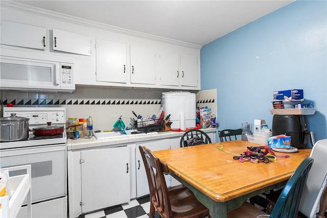 9 Nickerson St, Pawtucket, RI 02860 - kitchen featuring white appliances, tile countertops, white cabinetry, backsplash, and light floors