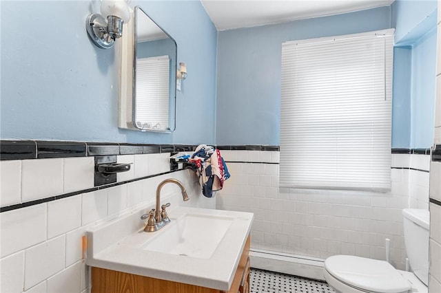9 Nickerson St, Pawtucket, RI 02860 - bathroom with a baseboard heating unit, tile walls, vanity, a wainscoted wall, and tile patterned floors
