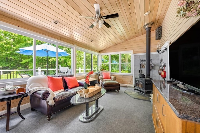 2470 W St, Wrentham, MA 02093 - living area featuring wooden ceiling, lofted ceiling, a wood stove, ceiling fan, and wood walls
