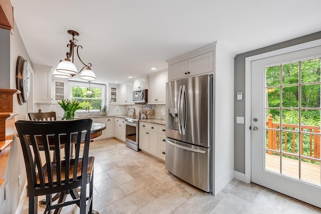 2470 W St, Wrentham, MA 02093 - kitchen featuring stainless steel appliances, tasteful backsplash, white cabinetry, decorative light fixtures, and light stone countertops