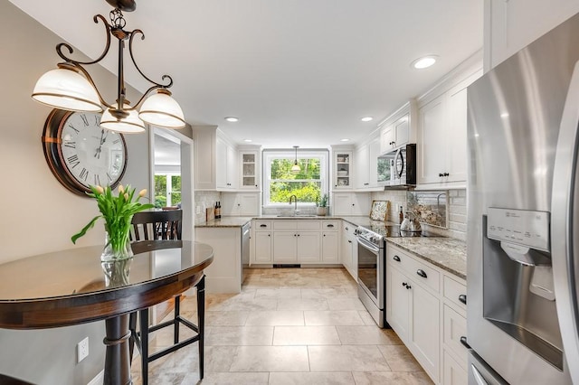 2470 W St, Wrentham, MA 02093 - kitchen with appliances with stainless steel finishes, white cabinets, tasteful backsplash, glass insert cabinets, and recessed lighting