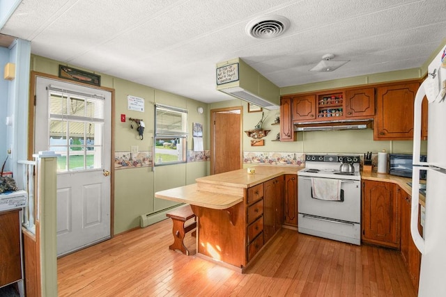29 Cantaberry Ln, Coventry, RI 02816 - kitchen featuring electric range, a peninsula, light countertops, brown cabinetry, and light wood finished floors