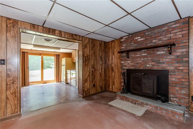 14 Meadow View Dr, Smithfield, RI 02917 - unfurnished living room featuring concrete flooring, a drop ceiling, a brick fireplace, and wooden walls