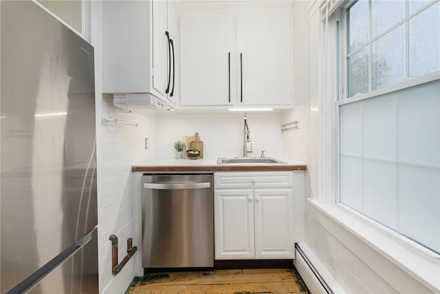 43 Cherry Ln Unit B, South Kingstown, RI 02879 - kitchen with stainless steel appliances, white cabinetry, light countertops, backsplash, and light wood-style flooring