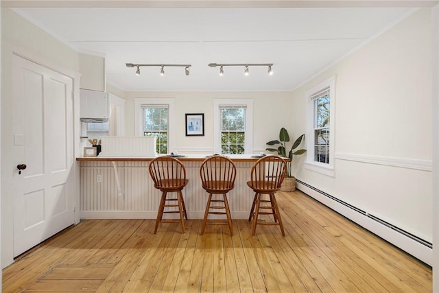 43 Cherry Ln Unit B, South Kingstown, RI 02879 - kitchen featuring baseboard heating, a breakfast bar, light wood-style floors, and a peninsula