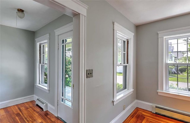 129 Ash St, Warwick, RI 02888 - doorway to outside with a baseboard radiator and wood finished floors