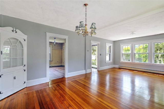 129 Ash St, Warwick, RI 02888 - empty room with baseboard heating, a chandelier, and wood finished floors
