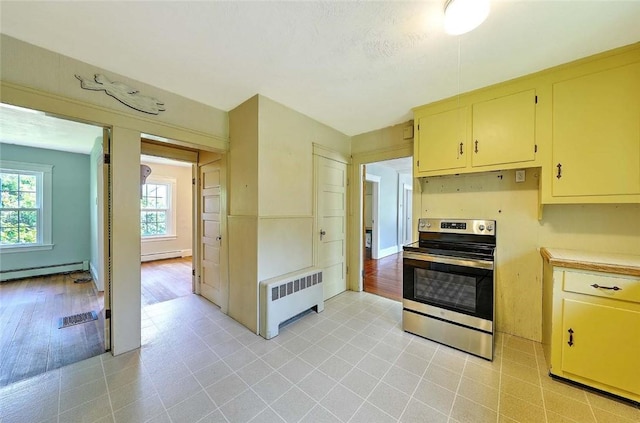 129 Ash St, Warwick, RI 02888 - kitchen featuring radiator heating unit, electric stove, plenty of natural light, and baseboard heating