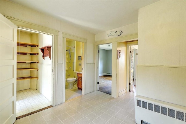 129 Ash St, Warwick, RI 02888 - hallway with radiator heating unit, light tile patterned floors, and a baseboard radiator