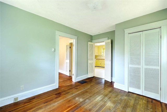 129 Ash St, Warwick, RI 02888 - unfurnished bedroom with dark wood-style flooring and a closet