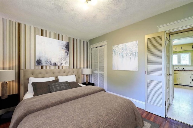 129 Ash St, Warwick, RI 02888 - bedroom featuring wood finished floors, multiple closets, a textured ceiling, and wallpapered walls