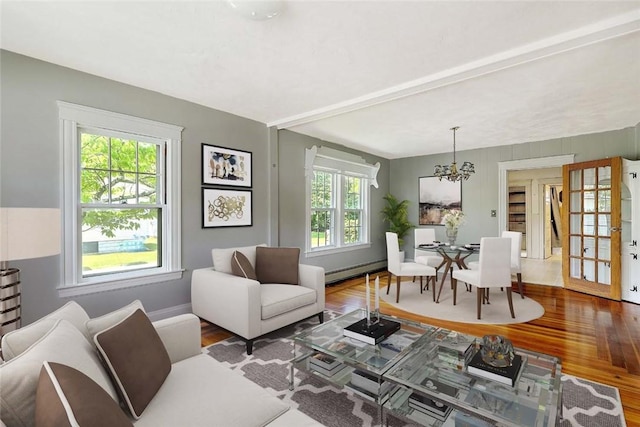 129 Ash St, Warwick, RI 02888 - living area with wood finished floors, a chandelier, a baseboard heating unit, and french doors