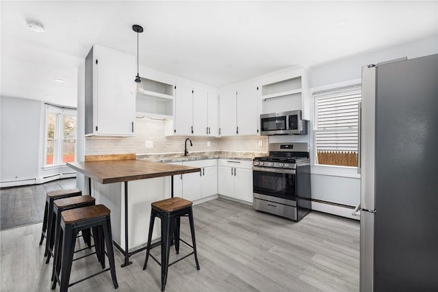 122 Willow St, Providence, RI 02909 - kitchen with open shelves, appliances with stainless steel finishes, a baseboard heating unit, and wood counters