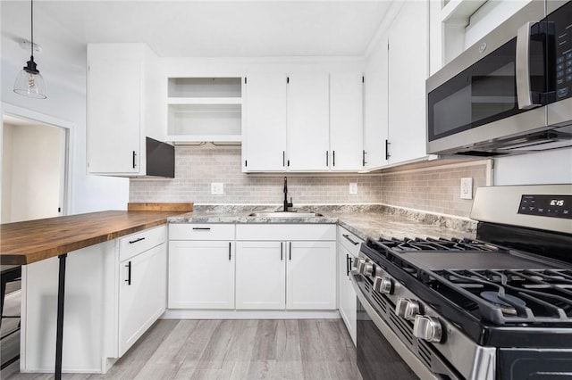 122 Willow St, Providence, RI 02909 - kitchen featuring appliances with stainless steel finishes, butcher block counters, open shelves, light wood-type flooring, and white cabinetry