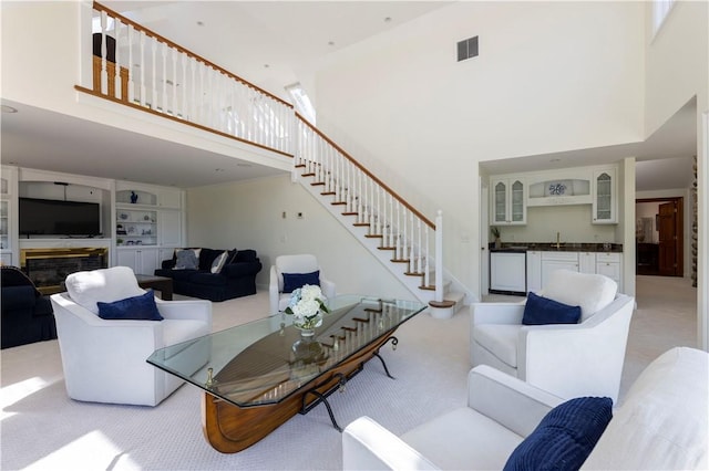 121 Avondale Rd, Westerly, RI 02891 - living area featuring a towering ceiling, stairs, and light carpet