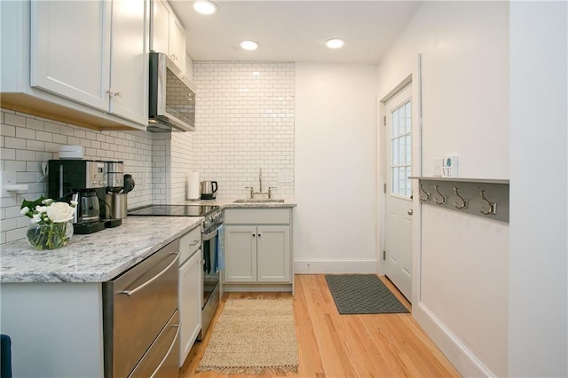 12 Poplar St, Newport, RI 02840 - kitchen featuring appliances with stainless steel finishes, light wood-style flooring, tasteful backsplash, and recessed lighting
