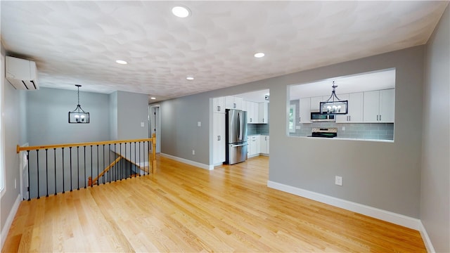 112 Cranberry Ridge Rd, Glocester, RI 02857 - empty room featuring a chandelier, a wall unit AC, light wood-type flooring, and recessed lighting