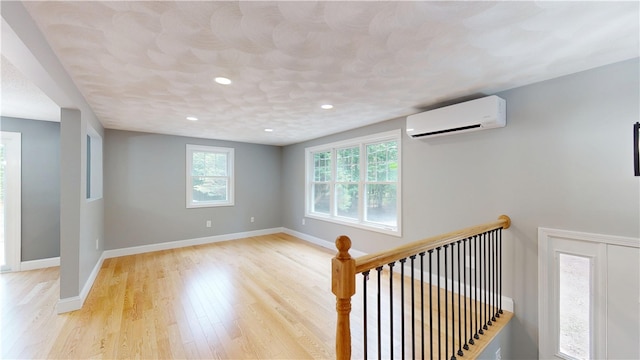 112 Cranberry Ridge Rd, Glocester, RI 02857 - empty room with an AC wall unit, light wood-style floors, and recessed lighting