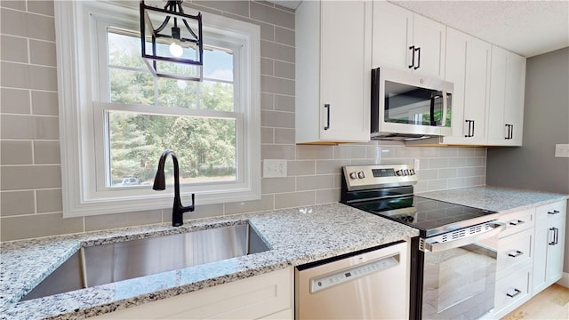 112 Cranberry Ridge Rd, Glocester, RI 02857 - kitchen featuring stainless steel appliances, light stone counters, backsplash, white cabinetry, and a textured ceiling