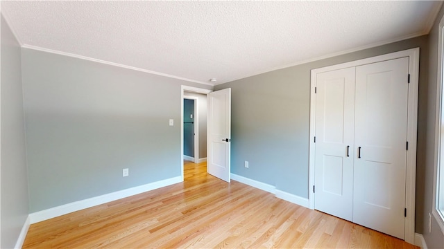 112 Cranberry Ridge Rd, Glocester, RI 02857 - unfurnished bedroom with a textured ceiling, a closet, light wood-style flooring, and crown molding